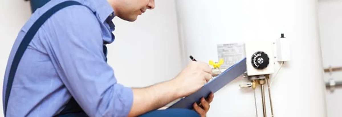 Water heater repair technician inspecting the unit and recording service notes in Ann Arbor, MI